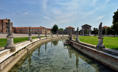 the oval canal around the fountain in Prato della Valle in Padua, Italy. Big old church.