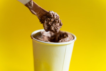 Paper cup with chocolate ice cream, just out of the freezer.