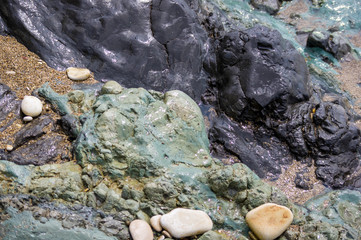 pebble stones on the sea beach, the rolling waves of the sea with foam