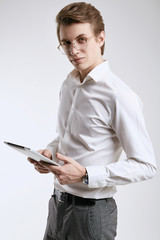 Confident young businessman in shirt working on digital tablet