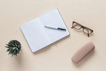 notebook with pen and glasses on table  top view with copy space for your text. flat lay. 