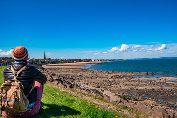 Fototapeta na wymiar Scenic view of Portobello beach with a tourist. Edinburgh, Scotland, UK.