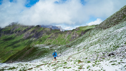 A runner on the snowy trails of the Alps in spring - 270263589