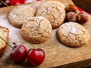Oatmeal cookies and cherry on kitchen cutting board gingham checkered cotton fabric on table in village style for picnic. Culinary masterpiece on table. Tea gatherings with friends. Nut sweets.