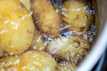 Jersey royal potatoes cooking in boiling water in a large saucepan