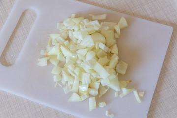 Thinly sliced raw onion on a chopping board for cooking