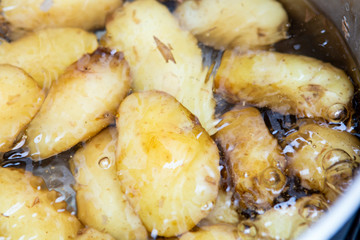 Jersey royal potatoes cooking in boiling water in a large saucepan