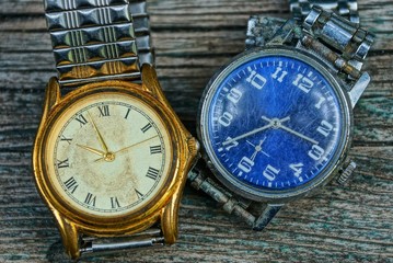 two yellow and blue old shabby watch with a metal strap 