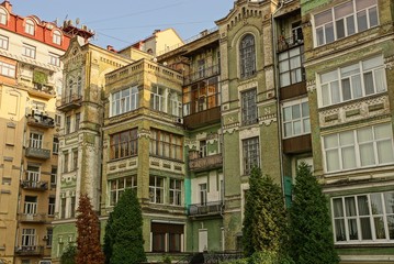 Fototapeta na wymiar gray and brown high apartment buildings on a city street against the sky