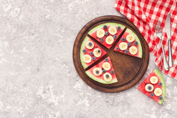 Sliced juicy watermelon pizza with blueberries and bananas