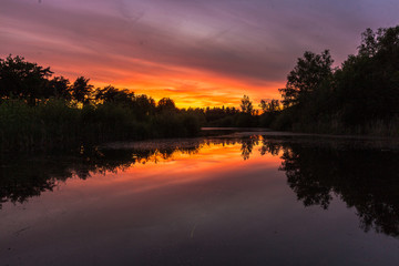 Fototapeta premium Sunset in the national park near Waterschei in Genk, Belgium with amazing colors in the sky. The park is a former mining area with amazing views