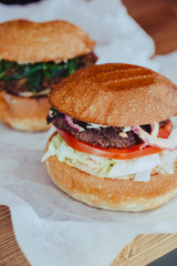 Two Classic Luxurious Authorized Burger with Cheese, with Lettuce, Onions, Tomatoes and Bun on a Wooden Background