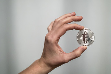Cryptocurrency golden bitcoin coin. Man holding in hand symbol of crypto currency - electronic virtual money for web banking and international network payment, selective focus, toned