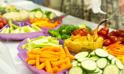 People serving from veggie tray
