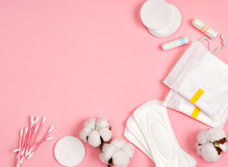 All made of cotton. Hygiene accessories - sanitary napkins, cotton pads, cotton swabs, tampons on pink background. Concept of critical days, menstruation