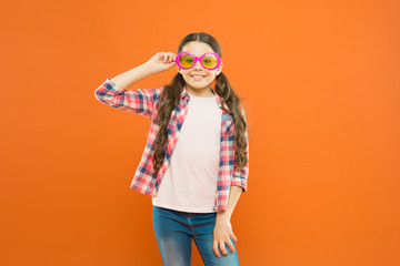 Look well and feel beautiful. Adorable girl with fashionable look on orange background. Little child having geeky look in fancy eyeglasses. Beauty look of small fashion model