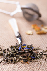 Obraz na płótnie Canvas Dried leaves of herbal green tea with the addition of citrus peel and blue flowers