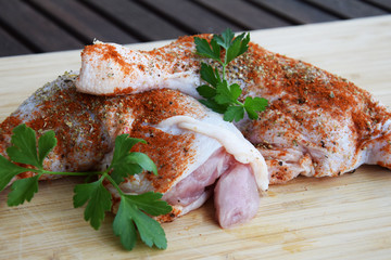 chicken legs in spices with tomatoes, herbs, parsley and hot peppers on the grill