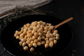 chikpeas in a dark plate with thyme