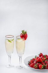 two glasses of champagne and a plate of strawberries