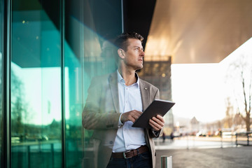 Businessman using tablet outside a building in the city