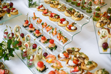 Catering. Off-site food. Buffet table with various canapes, sandwiches, hamburgers and snacks.