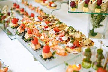 Catering. Off-site food. Buffet table with various canapes, sandwiches, hamburgers and snacks.