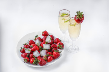 two glasses of champagne and a plate of strawberries