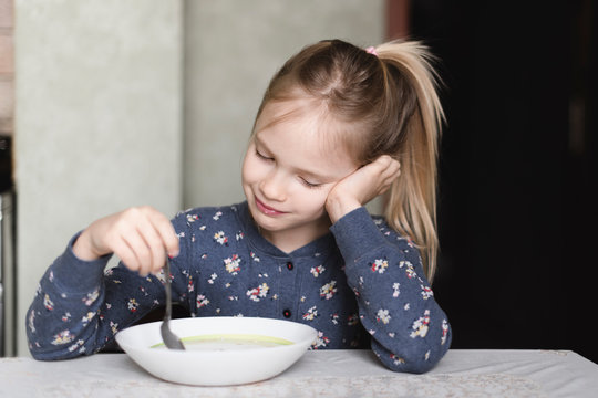 Portrait of smiling little girl eating oat meal
