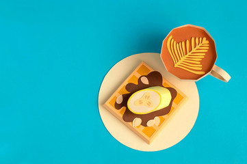 Belgian waffles with chocolate and banana, cup of cappuccino made of paper