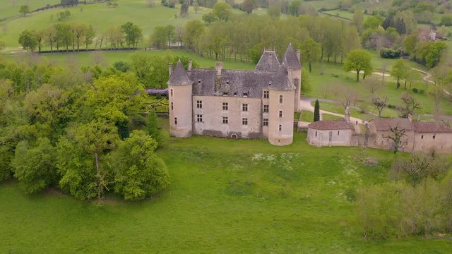 Side view of Chateau Montal (Castle of Montal)  surrounded by meadows, fields and farms.
