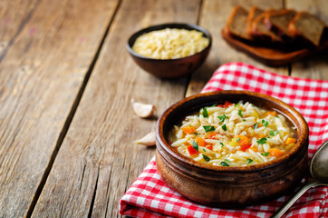 Turkey orzo vegetables soup with fresh rye bread slices