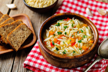 Turkey orzo vegetables soup with fresh rye bread slices