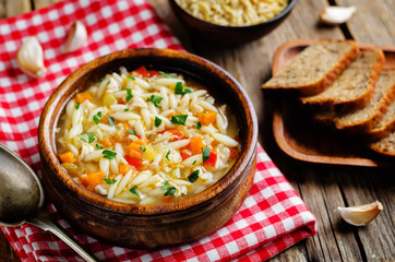 Turkey orzo vegetables soup with fresh rye bread slices