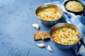 Turkey orzo vegetables soup with fresh rye bread slices