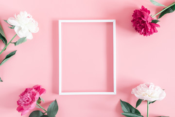 Minimal flowers composition. Blank frame for text, beautiful peonies flowers on pastel pink...