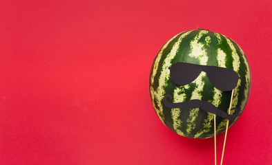 Striped watermelon with sunglasses and moustache photo props