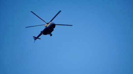 Fototapeta na wymiar Blue and silver police helicopter flying above