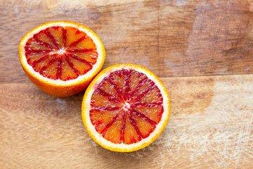 freshly cut blood oranges on a wooden chopping board