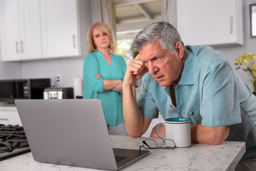 Retired senior couple upset and worried, concerned reading email on laptop computer