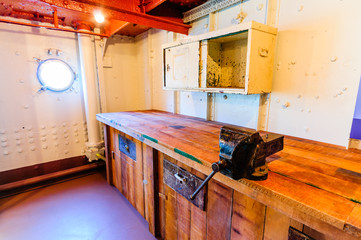 Engineer's workshop with bench and vice on board an old ship.