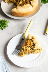 Pie with cabbage, eggs and parsley filling. Light stone background. 