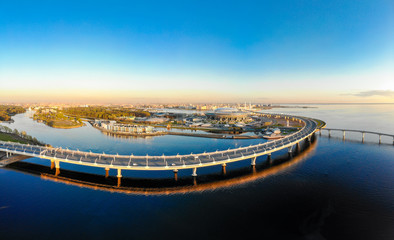 Aerial view of Football stadium Zenit Arena at sunset and new road - Western High Speed Diameter connecting Krestovsky and Vasilyevsky Islands. Bridge Viaduct above Neva river. St. Petersburg, Russia.