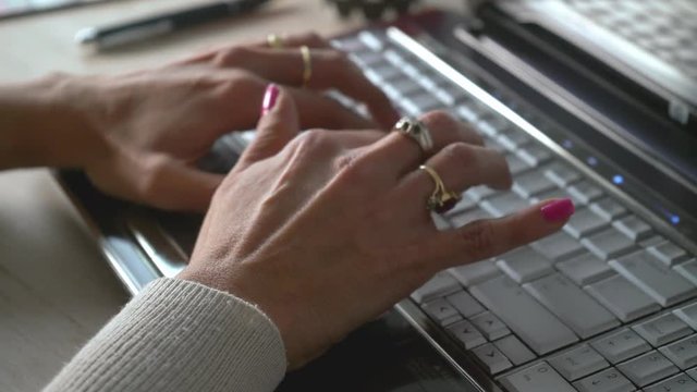 desplazamiento de derecha a izquierda de la camara  donde se observa las manos de una mujer tecleando una computadora