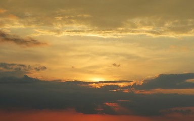 Beautiful orange golden sunset with black clouds, natural cloudscape