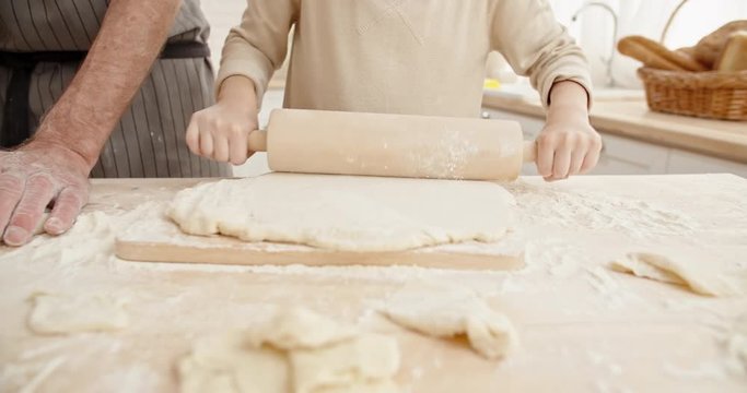 Unrecognizable granddad and granddaughter preparing bakery dough. Family members spending time together - family time, family ties concept 4k
