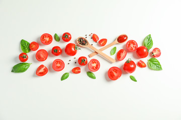 Naklejka na ściany i meble Flat lay composition with fresh tomatoes, pepper, basil and wooden spoons on white background, space for text. Ripe vegetables