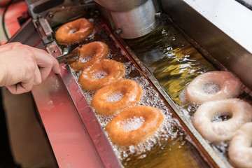 Preparation of fried donuts in a hot oil.