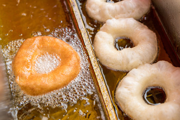 Preparation of fried donuts in a hot oil.