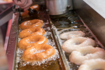 Preparation of fried donuts in a hot oil.